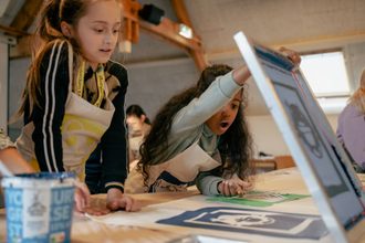 Kinderen werken aan zeefdruk workshop