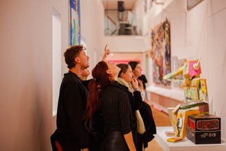Bezoekers tijdens een rondleiding door tentoonstellingzaal Panorama Amsterdam.