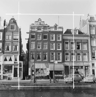 Zwart-witfoto van huizen aan een Amsterdamse gracht met geparkeerde auto's en fietsen.