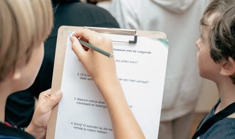 Kinderen schrijven op klembord