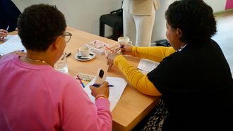 Mensen zitten rond een tafel te schrijven