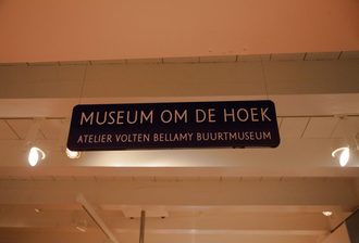 Bordje met tekst 'Museum om de hoek' en in het klein eronder 'Atelier Volten Bellamy Buurtmuseum'