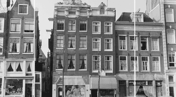 Zwart-witfoto van huizen aan een Amsterdamse gracht met geparkeerde auto's en fietsen.
