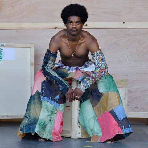 Portret van persoon met kleurrijke broek en kleurrijke armkleding