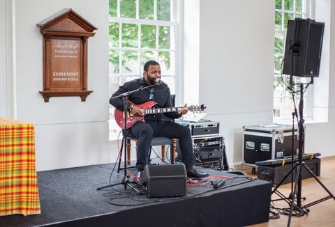 Keti Koti in het Amsterdam Museum persoon treedt op met gitaar