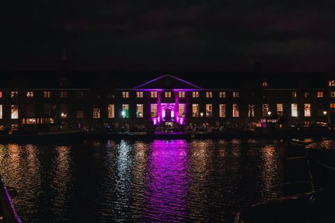 Amsterdam Museum in  H'ART gebouw vanaf Amstel met roze lichten