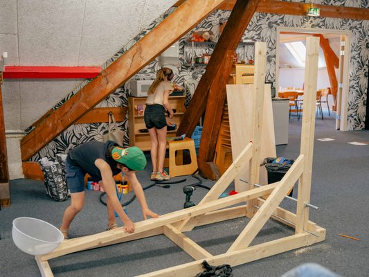 Kind werkt aan houten kunstwerk