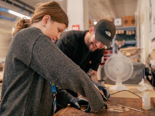 Kunstenaar helpt kind met kunstwerk