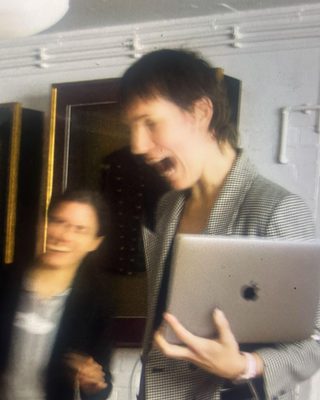 Kunstenaar Tessel Bruhl heeft een laptop vast en kijkt geschrokken.
