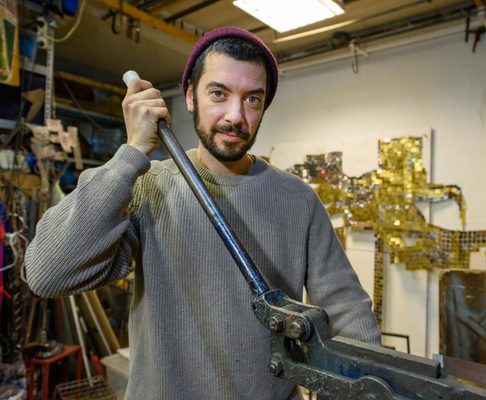 Daniele Scauso aan het werk met hand om machine heen.